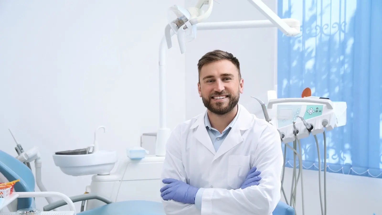 hero-smiling male dentist sitting